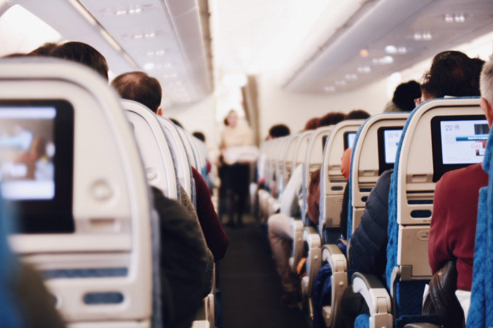 Airplane passengers in their seats – Air Travel and the Pandemic: an Epidemiologist’s Perspective
